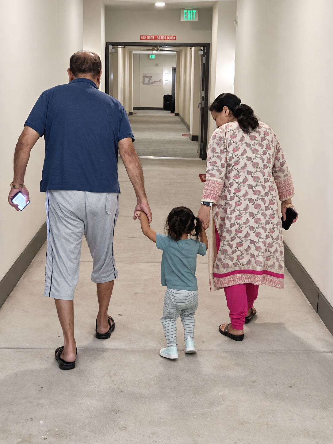 Aria walking hand in hand with her grandparents