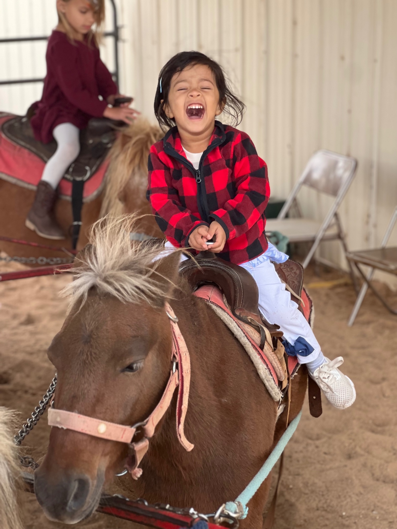 Aria laughing with pure joy while riding a pony
