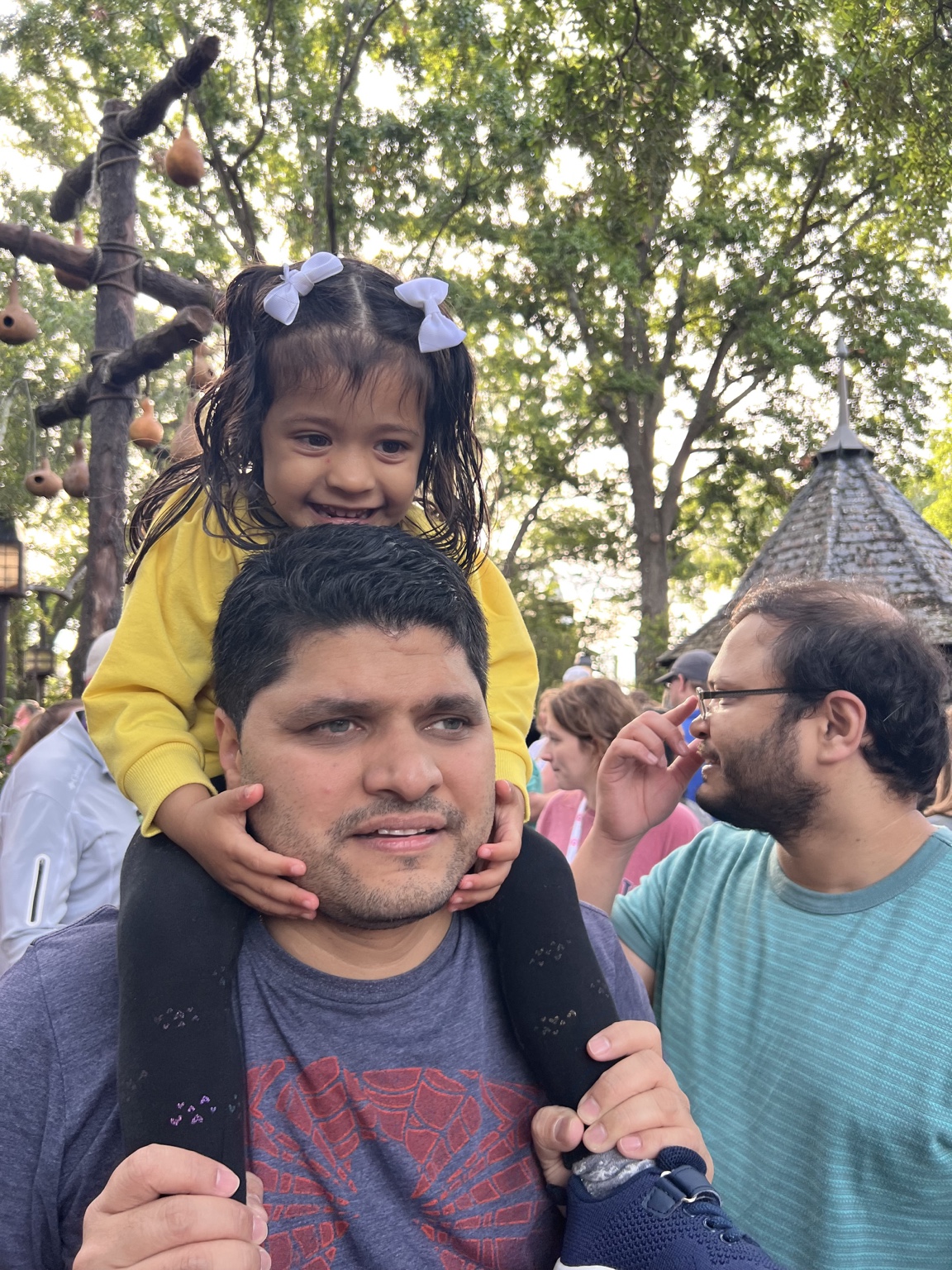 Aria beaming while riding on her uncle's shoulders
